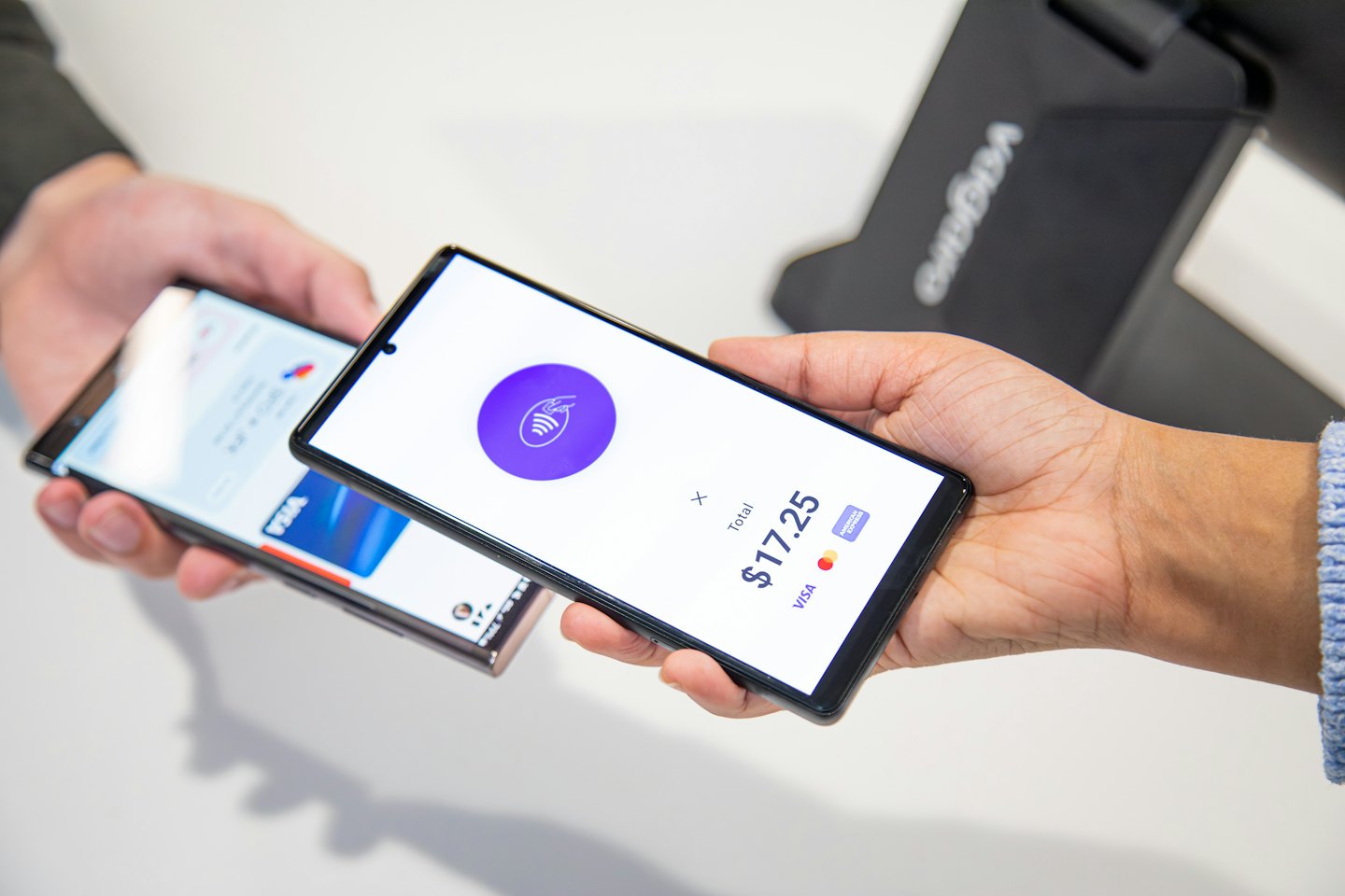 Dwie osoby dokonujące płatności mobilnej za pomocą smartfonów.